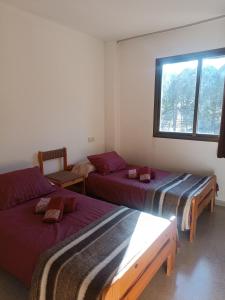 Zimmer mit 3 Betten und einem Fenster in der Unterkunft Apartamento a pie de pistas Port del Comte in La Coma i la Pedra