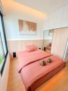ein Schlafzimmer mit einem großen rosa Bett mit zwei Kissen darauf in der Unterkunft Villa Kamar Tamu Balecatur 2 in Sleman