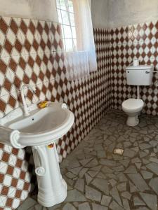 uma casa de banho com um lavatório branco e um WC. em Camping Sitaba Lodge em Georgetown