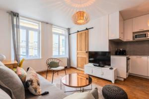 a living room with a couch and a table at Charmant appartement une chambre - hypercentre ! in Lille