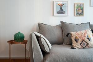 a couch with pillows and a table in a living room at Charmant appartement une chambre - hypercentre ! in Lille