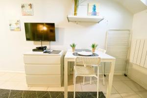 a room with a desk with two chairs and a tv at The Champo studio Near the city centre #B2 in Grenoble