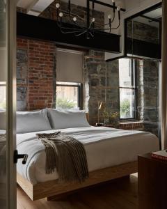 a bedroom with a large bed with a brick wall at The Smith Hotel in Kingston