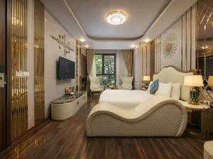ein Schlafzimmer mit einem großen weißen Bett und einem TV in der Unterkunft Bao Ngoc Hotel Linh Dam in Hanoi
