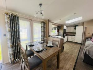 a dining room and kitchen with a table and chairs at Waterside Retreat With Hot Tub in Pocklington