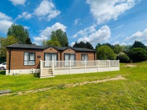 a log cabin with a white fence in a yard at Waterside Retreat With Hot Tub in Pocklington