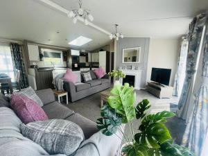 a living room with a couch and a tv at Waterside Retreat With Hot Tub in Pocklington