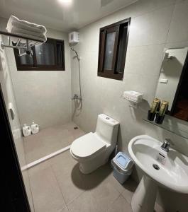 biała łazienka z toaletą i umywalką w obiekcie Blue Mountain Inn w mieście Jinning