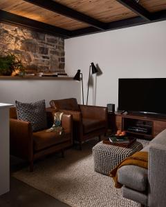 a living room with leather furniture and a flat screen tv at The Smith Hotel in Kingston