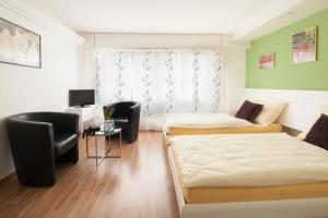 a room with two beds and a desk and a tv at Metropol in Biel