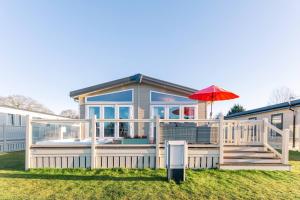 a house with a deck with an umbrella at Lakeside Gem with Hot Tub in York