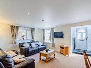 a living room with a leather couch and a table at 2 Bed in Langtoft 82339 in Weaverthorpe