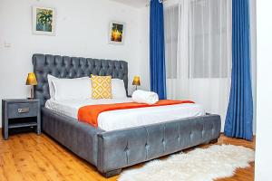 - une chambre avec un grand lit et des rideaux bleus dans l'établissement Casa Misa Riverside Duplex, à Nairobi