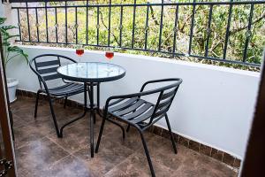dos sillas y una mesa con dos copas de vino en Casa Misa Riverside Duplex en Nairobi