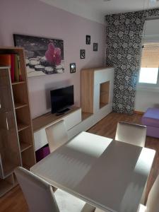 a living room with a table and chairs and a tv at Orizzonti in Trieste