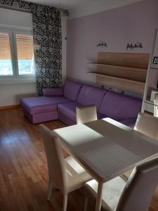 a living room with a purple couch and a table at Orizzonti in Trieste