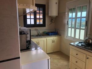 uma cozinha com armários brancos e um forno com placa de fogão em Mina House em Chefchaouen