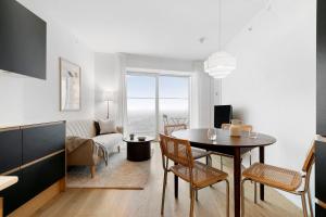 a kitchen and living room with a table and chairs at Penthouse paradise on 39th floor in Aarhus