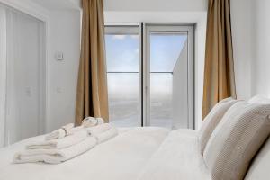 una cama blanca con toallas delante de una ventana en Penthouse paradise on 39th floor en Aarhus