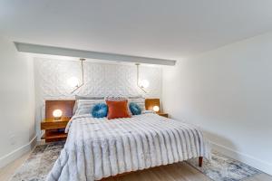 a white bedroom with a large bed with orange and blue pillows at Stylish Pet-Friendly Denver Gem, 2 Mi to Downtown! in Denver