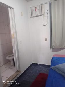 a bathroom with a toilet and a bed in a room at Apartamento Aconchegante in Rondonópolis