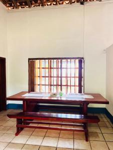 a wooden table in a room with a window at Cacerola Beach House in Poneloya