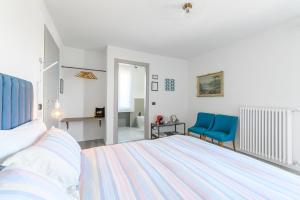 sypialnia z łóżkiem i 2 niebieskimi krzesłami w obiekcie Villa Rocco Country House w mieście Ozzano Monferrato
