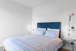 a bedroom with a large bed with a blue headboard at Villa Rocco Country House in Ozzano Monferrato