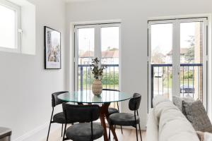ein Wohnzimmer mit einem Tisch, Stühlen und einem Sofa in der Unterkunft The Wembley Park Wonder - Charming 2BDR Flat with Balcony in London