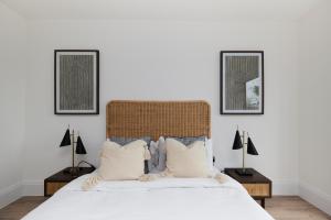 una camera con un letto bianco con due immagini sul muro di The Wembley Park Wonder - Charming 2BDR Flat with Balcony a Londra