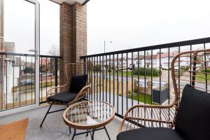 a balcony with two chairs and a table at The Wembley Park Wonder - Charming 2BDR Flat with Balcony in London