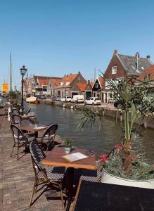 een rij tafels en stoelen naast een rivier bij Surla luxury sailing Houseboat Splendid at Marina Monnickendam in Monnickendam
