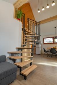 a staircase in a living room with a couch and a table at Apartment Orehar in Bohinj