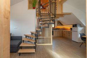 a spiral staircase in a living room next to a kitchen at Apartment Orehar in Bohinj