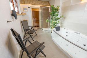 bagno con 2 sedie e doccia di Apartment Orehar a Bohinj