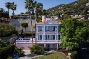 a large pink house with a porch at Villa Fantaisie in Menton