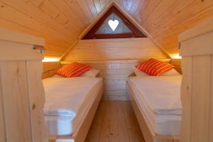 two beds in a tiny house bedroom with a window at Apartment Orehar in Bohinj