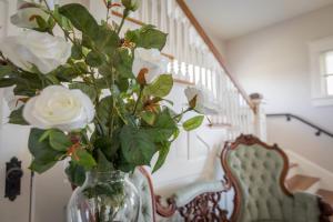 a vase filled with white roses sitting on a table at Clifton House - Big River South - Mississippi River Views, Queen Suite in Natchez