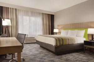 a hotel room with a bed and a desk at Country Inn & Suites by Radisson, Oklahoma City - Bricktown, OK in Oklahoma City +20 photos