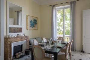 a dining room with a table and a fireplace at Villa Fantaisie in Menton
