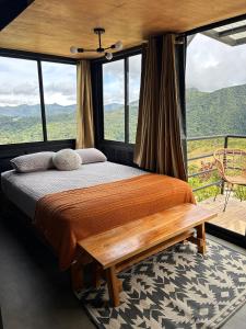 a bedroom with a bed and a large window at Nomada Republic Hotel El valle in Antón