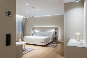 a white bedroom with a bed and a table at Royal Ramblas in Barcelona