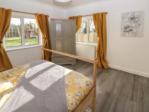 a bedroom with a bunk bed and two windows at The Old Well Bungalow - Ty Mawr Farm in Cardiff