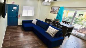 a living room with a blue couch and a table at MeMe's Place in Placencia Village