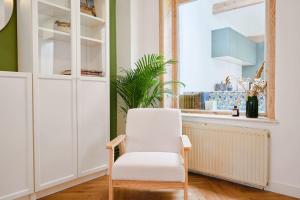 Una silla blanca en una habitación con ventana en Charmante maison 3 chambres avec jardin., en La Madeleine