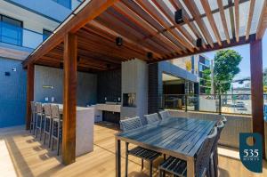 a kitchen and dining room with a wooden table and chairs at Lindo Apartamento Quarto e Sala em Salvador in Salvador