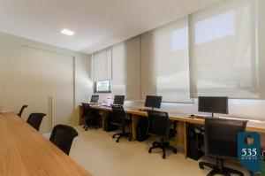 um escritório com uma longa mesa com cadeiras e uma grande janela em Lindo Apartamento Quarto e Sala em Salvador em Salvador