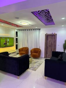 a living room with couches and a flat screen tv at Sambest Homes in Lagos