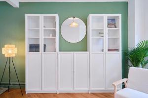 Armario blanco en una habitación con espejo en Charmante maison 3 chambres avec jardin., en La Madeleine