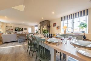 a kitchen and dining room with a long table and chairs at The Coach House R 6 in Ringstead